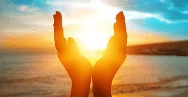 Mains entourant le soleil couchant du Solstice d'été